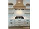 Designer kitchen features stainless gas range, custom cabinets, stylish vent hood, and open wood shelving at 15170 Cove Point Ln, Norwood, NC 28128