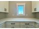 Butler's pantry features white cabinets, quartz countertops, a window with a picturesque view, and stylish hardware at 15170 Cove Point Ln, Norwood, NC 28128