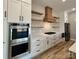 Well-appointed kitchen featuring stainless steel appliances, custom cabinets, open shelving, and quartz countertops at 15170 Cove Point Ln, Norwood, NC 28128