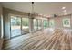 Spacious living room featuring wood floors, large windows, and modern lighting fixtures that enhance the bright airy atmosphere at 15170 Cove Point Ln, Norwood, NC 28128