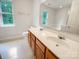 Bathroom featuring a double vanity with wooden cabinets, a garden tub, and natural light at 15188 Eric Kyle Dr, Huntersville, NC 28078