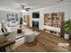 Bright living room with fireplace, built-in bookshelves, wood floors, and striped furniture at 15188 Eric Kyle Dr, Huntersville, NC 28078