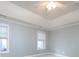 Bedroom with neutral walls, two windows with blinds, tray ceilings, and carpeted floors at 1520 Royalty Cir, Statesville, NC 28625