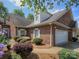 Charming brick home features a two-car garage and neatly landscaped yard with flowering bushes at 1520 Royalty Cir, Statesville, NC 28625