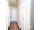 Hallway with hardwood floors, multiple doors, and neutral walls at 1520 Royalty Cir, Statesville, NC 28625