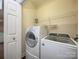 Bright laundry room featuring modern, white appliances, shelving, and a convenient door to the side at 1520 Royalty Cir, Statesville, NC 28625