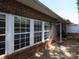 The red brick patio features windows offering natural light and a seamless transition to indoor living at 1520 Royalty Cir, Statesville, NC 28625