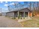 View of house with covered front porch, gravel driveway, and small building at 1595 Cheatham Ford Rd, Hiddenite, NC 28636