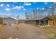 View of house and oversized metal building with gravel driveway at 1595 Cheatham Ford Rd, Hiddenite, NC 28636