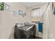 Laundry room with washer, dryer and painted walls with decorative pictures at 1595 Cheatham Ford Rd, Hiddenite, NC 28636