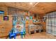 Bright room featuring wooden walls, blue curtains, a table, and folding chairs at 1595 Cheatham Ford Rd, Hiddenite, NC 28636