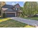 Two-story home with a gray garage door, covered front porch, stone accents and a long concrete driveway at 1650 Berkshire Dr, Hickory, NC 28602