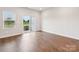 Bright living room featuring hardwood floors, large windows, and a sliding glass door to backyard at 1910 Old Rivers Rd, Concord, NC 28027