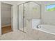 Bathroom showcases a glass-enclosed shower and a luxurious soaking tub with marble-look tile at 20422 Creek Bend Edge Ct, Matthews, NC 28105