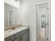 Bathroom featuring gray cabinets, brushed gold fixtures, a large mirror, and tile floors at 20422 Creek Bend Edge Ct, Matthews, NC 28105