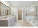 Bathroom featuring double sinks, a glass shower, tub, and elegant finishes at 20422 Creek Bend Edge Ct, Matthews, NC 28105