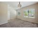 Bedroom featuring neutral carpet, two windows, and a modern light fixture, creating a welcoming space at 20422 Creek Bend Edge Ct, Matthews, NC 28105