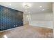 Upstairs bonus room featuring geometric blue accent wall, neutral carpet, and a modern light fixture at 20422 Creek Bend Edge Ct, Matthews, NC 28105