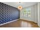 A dining room with wood floors, an accent wall, and a modern light fixture at 20422 Creek Bend Edge Ct, Matthews, NC 28105