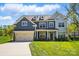 Charming two-story home with a manicured lawn, a two-car garage, and beautiful blue and grey siding at 20422 Creek Bend Edge Ct, Matthews, NC 28105