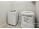Bright laundry room featuring modern washer and dryer with space-saving storage shelving at 20422 Creek Bend Edge Ct, Matthews, NC 28105
