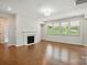 Bright living room featuring hardwood floors, a cozy fireplace, recessed lights and large windows at 20422 Creek Bend Edge Ct, Matthews, NC 28105
