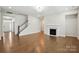 Spacious living room with hardwood flooring, fireplace, and staircase access, providing ample space at 20422 Creek Bend Edge Ct, Matthews, NC 28105