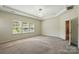 Main bedroom featuring a trey ceiling, large windows, and neutral carpet at 20422 Creek Bend Edge Ct, Matthews, NC 28105