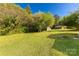 Lush backyard with a large shed, mature trees, and green grass at 212 W Doc Garris Rd, Lancaster, SC 29720
