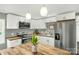 Bright kitchen features white cabinets, stainless steel appliances, and butcher block countertops, illuminated by pendant lighting at 212 W Doc Garris Rd, Lancaster, SC 29720