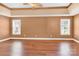 Spacious bedroom with hardwood floors, a ceiling fan, and natural light from two windows at 2275 Laurens Dr, Concord, NC 28027