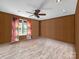 Spacious bedroom featuring a ceiling fan, natural light, and neutral-toned wood paneled walls at 2614 Reepsville Rd, Lincolnton, NC 28092