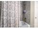 This bathroom features a standard tub with floral shower curtain and tiled surround at 2617 Brookwood Rd, Lincolnton, NC 28092