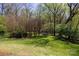 Lush backyard featuring mature trees, a green lawn, and a trampoline for outdoor enjoyment at 2815 Providence Spring Ln, Charlotte, NC 28270