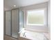 Bathroom with a jetted tub under a window and a glass door shower at 2815 Providence Spring Ln, Charlotte, NC 28270