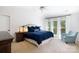 Bedroom with a blue cushioned chair, three windows, and dark wood furniture at 2815 Providence Spring Ln, Charlotte, NC 28270