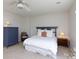 Comfortable bedroom with a ceiling fan, blue dresser, and a cushioned wicker chair at 2815 Providence Spring Ln, Charlotte, NC 28270