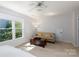 Bedroom with a window view, beige love seat, dark wooden chest, and a ceiling fan at 2815 Providence Spring Ln, Charlotte, NC 28270