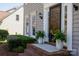 Close-up of a front door with sidelights, potted plants, and brick steps at 2815 Providence Spring Ln, Charlotte, NC 28270