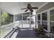 Enclosed porch with ceiling fan, seating, screened walls, and a peaceful view of the surrounding landscape at 2815 Providence Spring Ln, Charlotte, NC 28270