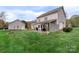 Backyard featuring covered patio, separate garage building, and well-maintained lawn at 301 Prairie Rose Ct, Waxhaw, NC 28173