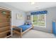 Bedroom featuring a wooden bed frame, window with patterned valance, and open shelving at 301 Prairie Rose Ct, Waxhaw, NC 28173