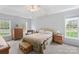 Comfortable bedroom with neutral color palette, plush carpet, dresser, and natural light from sunny windows at 301 Prairie Rose Ct, Waxhaw, NC 28173