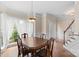 Dining room with hardwood floors, bright windows, traditional furnishings, and stairs leading to upper floor at 301 Prairie Rose Ct, Waxhaw, NC 28173