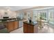 Kitchen featuring tile floors, green countertops, wood cabinets, and breakfast nook seating with natural light at 301 Prairie Rose Ct, Waxhaw, NC 28173