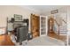 Functional office featuring built-in bookshelf and a view of the staircase adjacent through a french door at 301 Prairie Rose Ct, Waxhaw, NC 28173