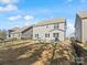 Backyard featuring a well-maintained lawn, patio with furniture, and black iron fence bordering multiple houses under a bright sky at 3036 Whipcord Dr, Waxhaw, NC 28173