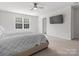Bright and well-lit bedroom featuring a ceiling fan, a wall-mounted TV, and a calming neutral color scheme at 3036 Whipcord Dr, Waxhaw, NC 28173