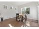 Sunlit dining area with hardwood floors, wood table and chairs, brightened by large windows at 3036 Whipcord Dr, Waxhaw, NC 28173