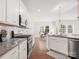Bright kitchen boasts granite countertops, stainless steel appliances, and view to dining area at 3036 Whipcord Dr, Waxhaw, NC 28173